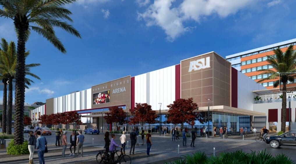 A modern arena with “ASU” and “Mullett Arena” signage stands under a blue sky. People walk and bike along the palm-lined street, with red-leaved trees and parked cars nearby. A digital marquee shows a sports image above the entrance.